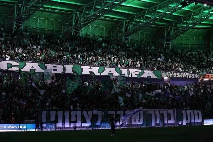 אוהדי מכבי חיפה עם שלט לכבוד מתן אנגרסט