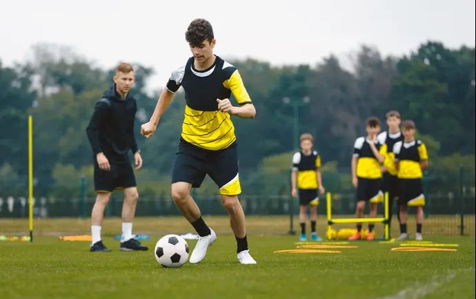 שחקן כדורגל בגיל נוער מכדרר