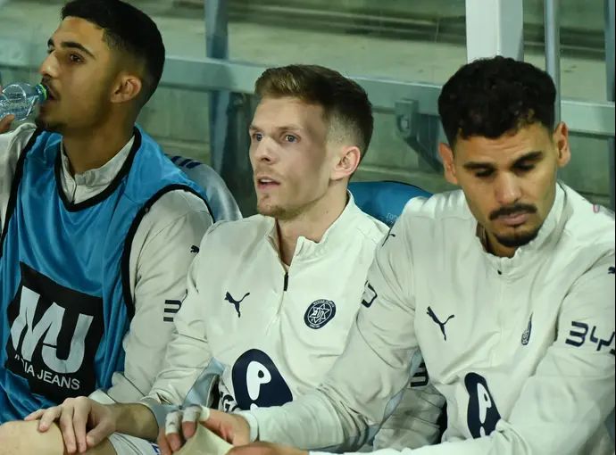 אמיר סהיטי שחקן מכבי תל אביב על הספסל בין רועי משפתי לבין אלעד מדמון