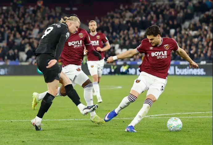 ארלינג הולאנד שחקן מנצ'סטר סיטי בועט מול קוסטאס מברופאנוס שחקן ווסטהאם