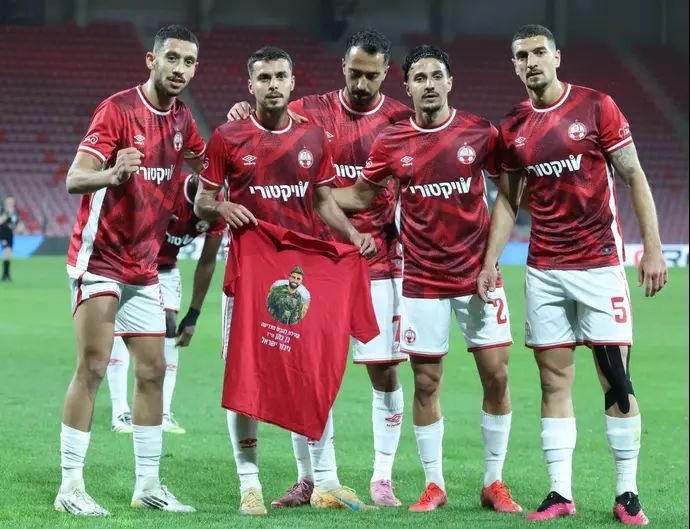 שחקני הפועל באר שבע חוגגים שער עם חולצה לזכרו של סמ"ר בן כהן ז"ל