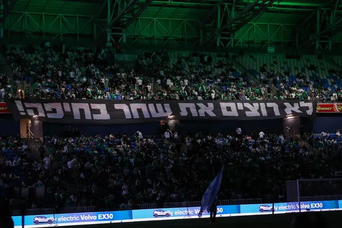 אוהדי מכבי חיפה עם שלט מחאה נגד הבעלים יעקב שחר