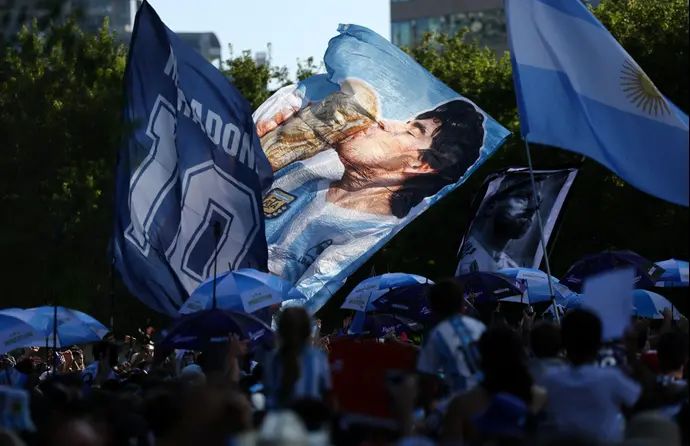 אוהדי נבחרת ארגנטינה מניפים דגל עם דמותו של דייגו מראדונה