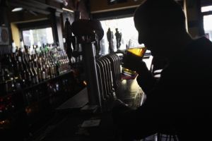 אדם שותה בירה בבר. אילוסטרציה