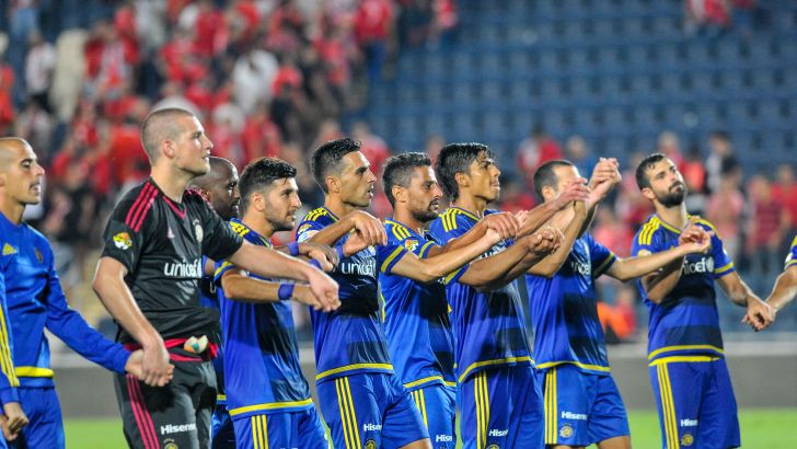 שחקני מכבי חוגגים עם ראיקוביץ'. ניצחון בבכורה