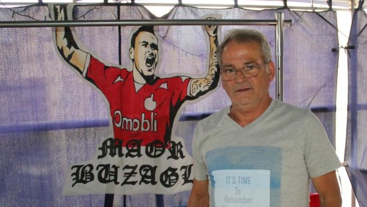 יעקב בוזגלו לצד הכרזה של מאור