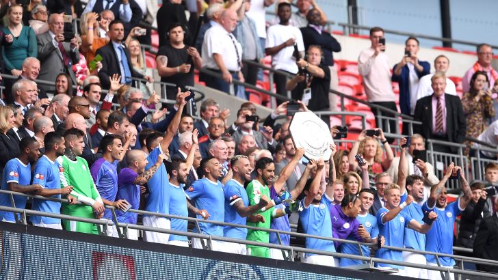 שחקני מנצ'סטר סיטי מניפים את מגן הקהילה